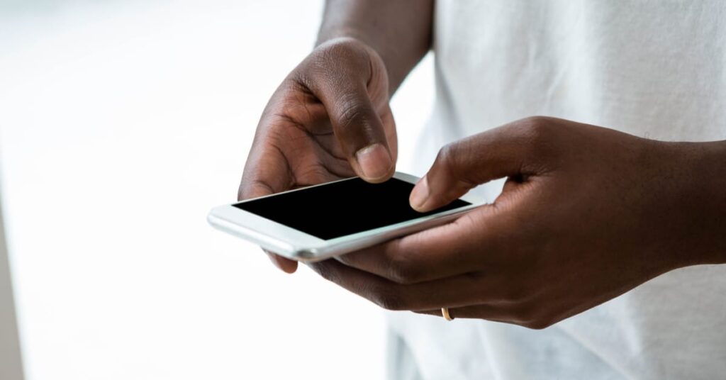 man typing on a smartphone